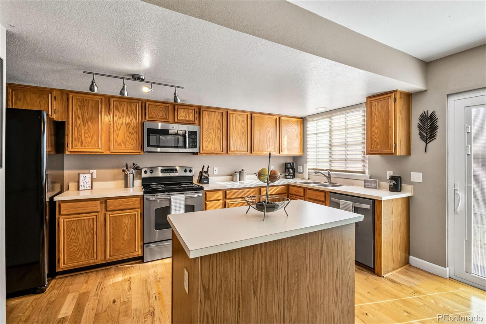 7670 Jared Way Littleton, CO 80125 - Photo 11 of 34 a kitchen with a sink a stove a refrigerator cabinets and a window