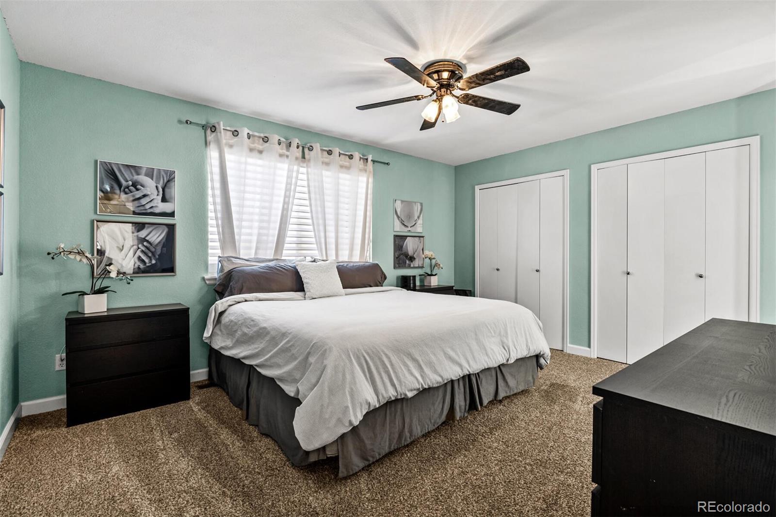 7670 Jared Way Littleton, CO 80125 - Photo 16 of 34 a bedroom with a bed and a chandelier