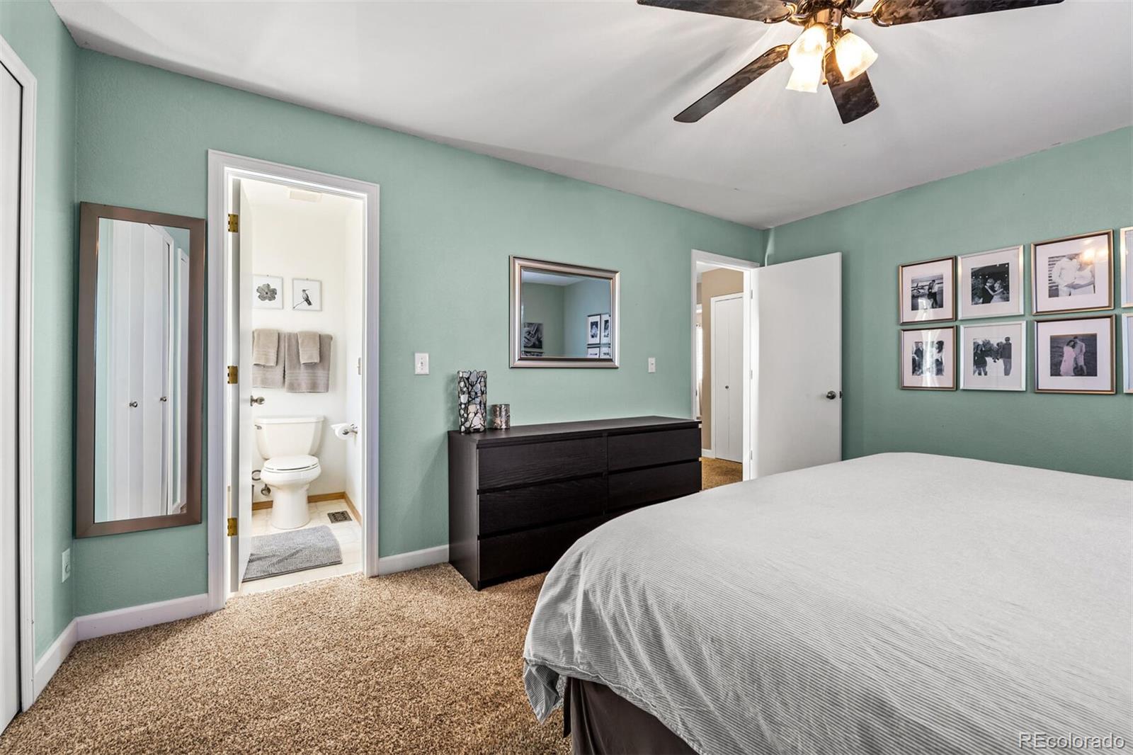 7670 Jared Way Littleton, CO 80125 - Photo 17 of 34 a bedroom with a bed and a chandelier