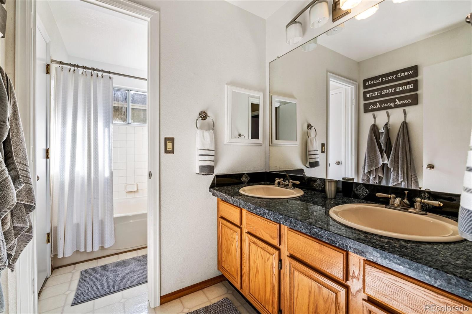 7670 Jared Way Littleton, CO 80125 - Photo 18 of 34 a bathroom with sink granite and a mirror