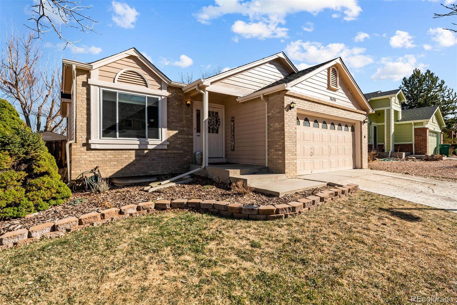 7670 Jared Way Littleton, CO 80125 - Photo 2 of 34 a front view of a house with a yard