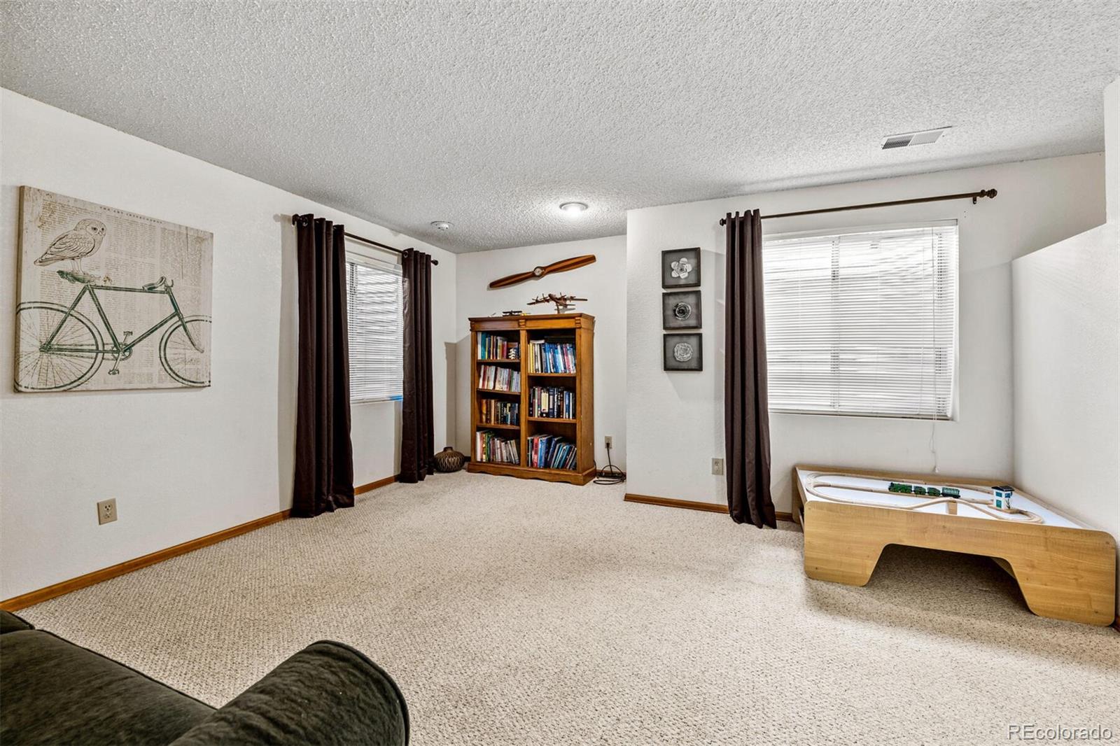 7670 Jared Way Littleton, CO 80125 - Photo 21 of 34 a spacious bedroom with a bed and a cabinets