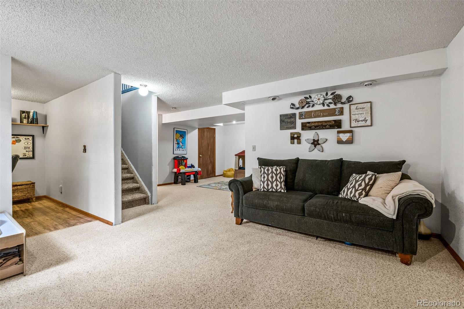 7670 Jared Way Littleton, CO 80125 - Photo 22 of 34 a living room with furniture and a flat screen tv