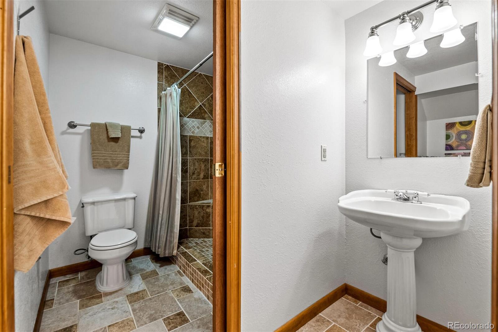 7670 Jared Way Littleton, CO 80125 - Photo 26 of 34 a bathroom with a sink toilet and shower