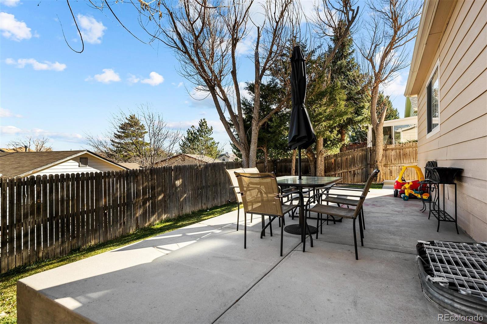 7670 Jared Way Littleton, CO 80125 - Photo 31 of 34 a view of a patio with a table and chairs