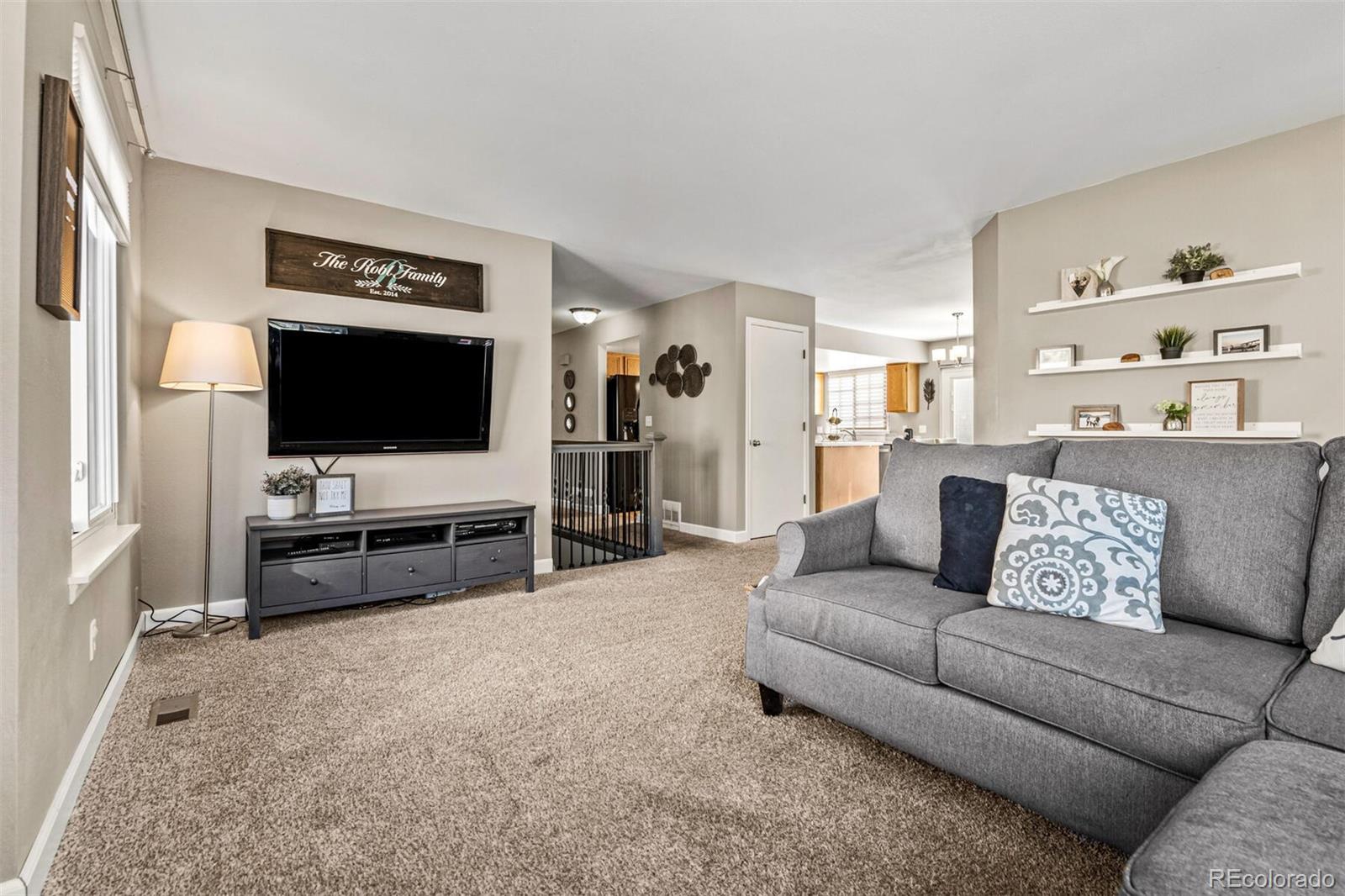 7670 Jared Way Littleton, CO 80125 - Photo 6 of 34 a living room with furniture and a flat screen tv