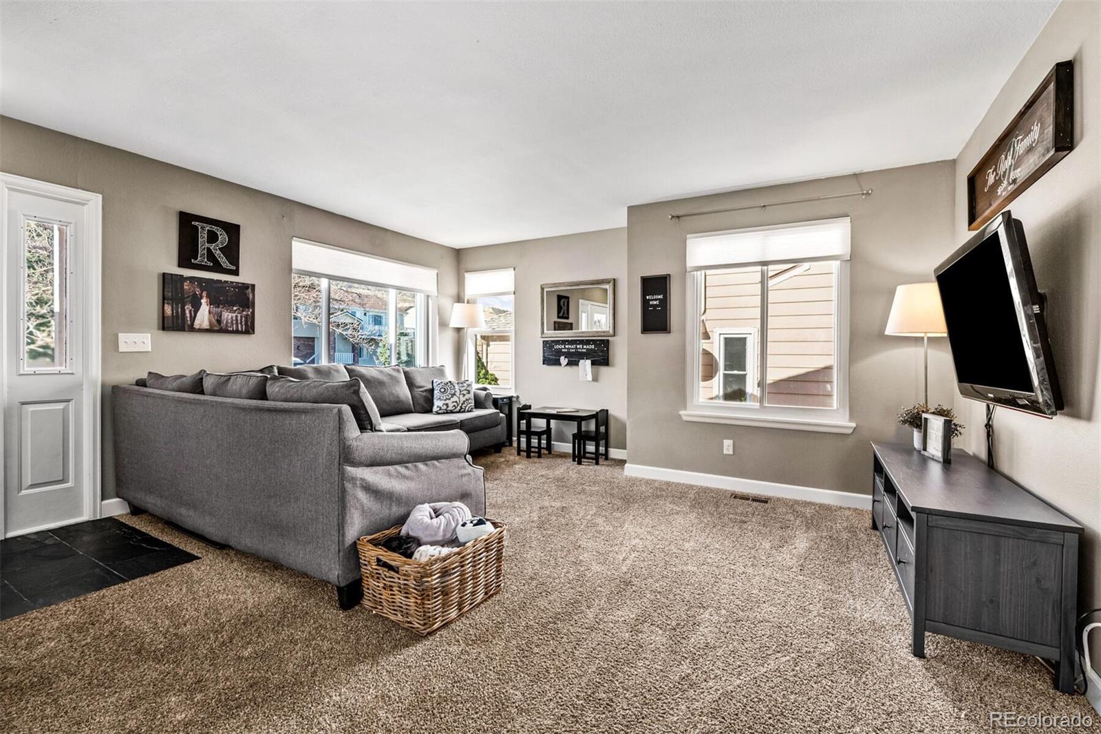 7670 Jared Way Littleton, CO 80125 - Photo 7 of 34 a living room with furniture and a flat screen tv
