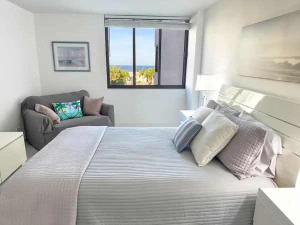 a bedroom with a bed and a painting on the wall