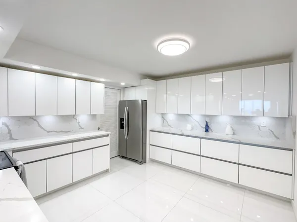 a kitchen with stainless steel appliances granite countertop a sink and a refrigerator