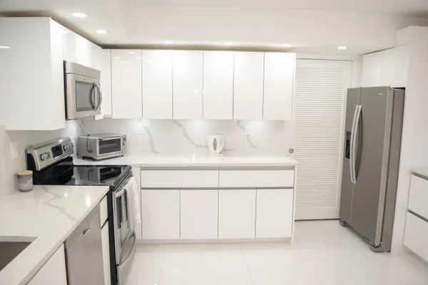 a kitchen with stainless steel appliances a refrigerator sink and cabinets