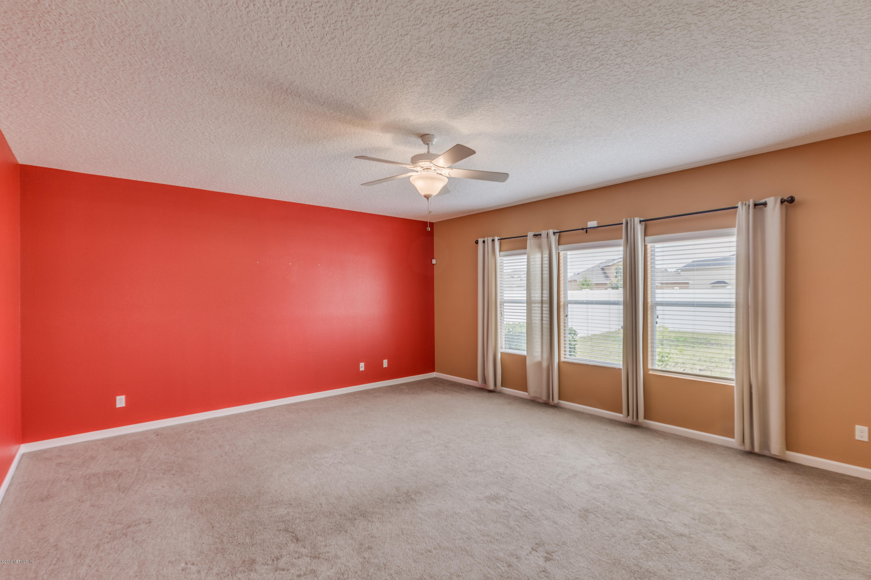16409 Tisons Bluff Road Jacksonville, FL 32218 - Photo 10 of 42 an empty room with chandelier fan and windows