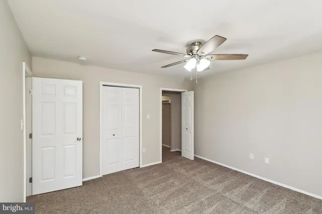 a view of an empty room with a ceiling fan
