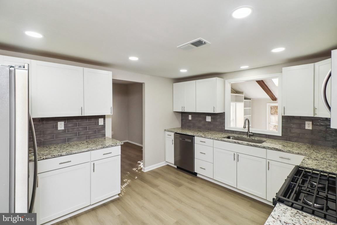 6551 Cornell Road Bryans Road, MD 20616 - Photo 9 of 25 a kitchen with granite countertop white cabinets and white appliances
