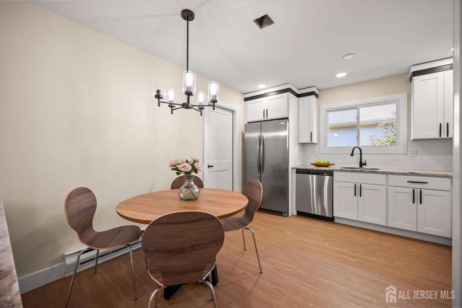 701 Croydon Road, Unit A Monroe Township, NJ 08831 - Photo 10 of 34 a kitchen with stainless steel appliances kitchen island granite countertop a refrigerator a stove a sink dishwasher with a dining table and chairs