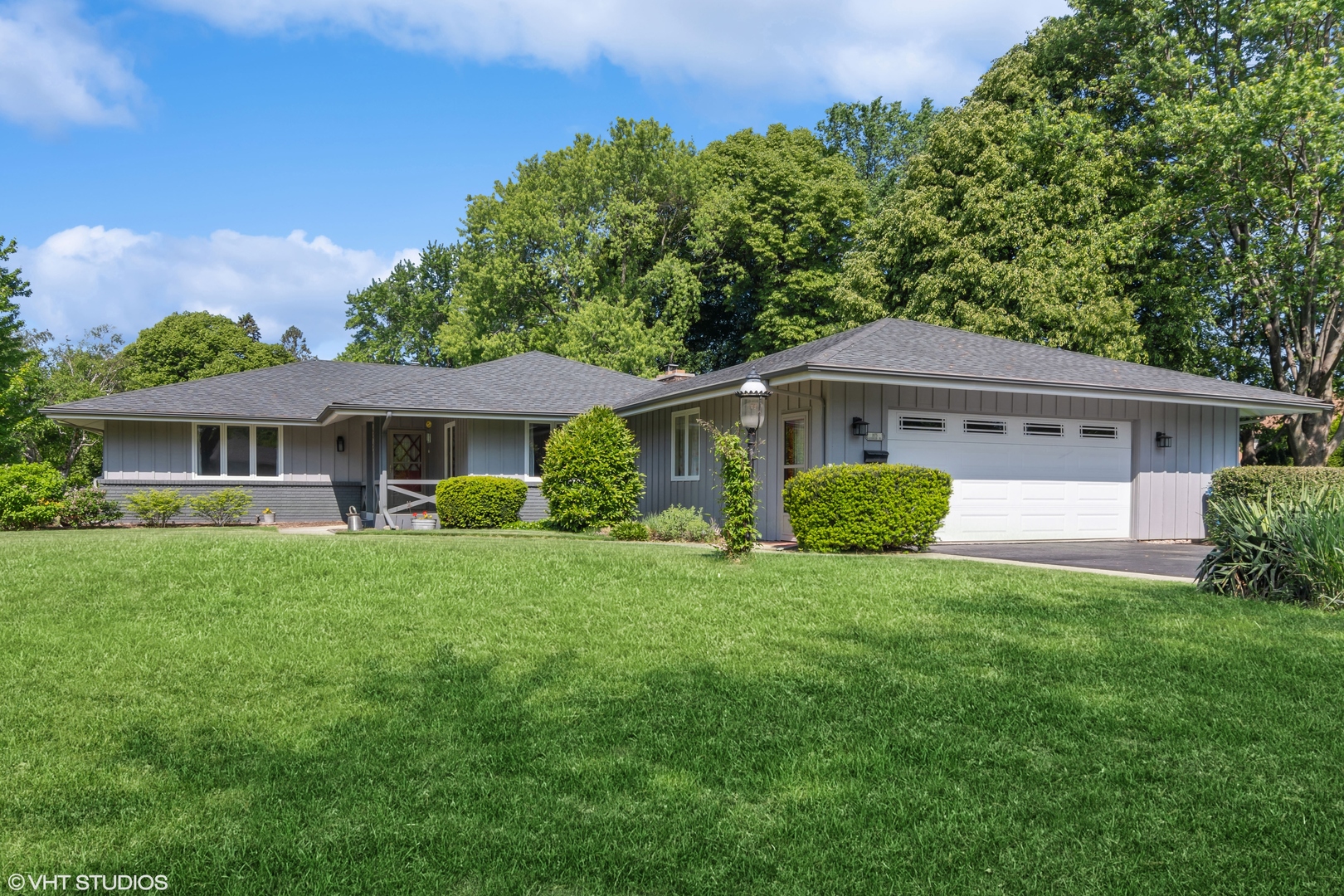 a front view of a house with a yard and trees