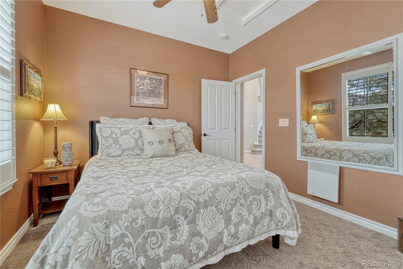 10761 Glengate Circle Highlands Ranch, CO 80130 - Photo 20 of 39 a bedroom with a bed and a chandelier