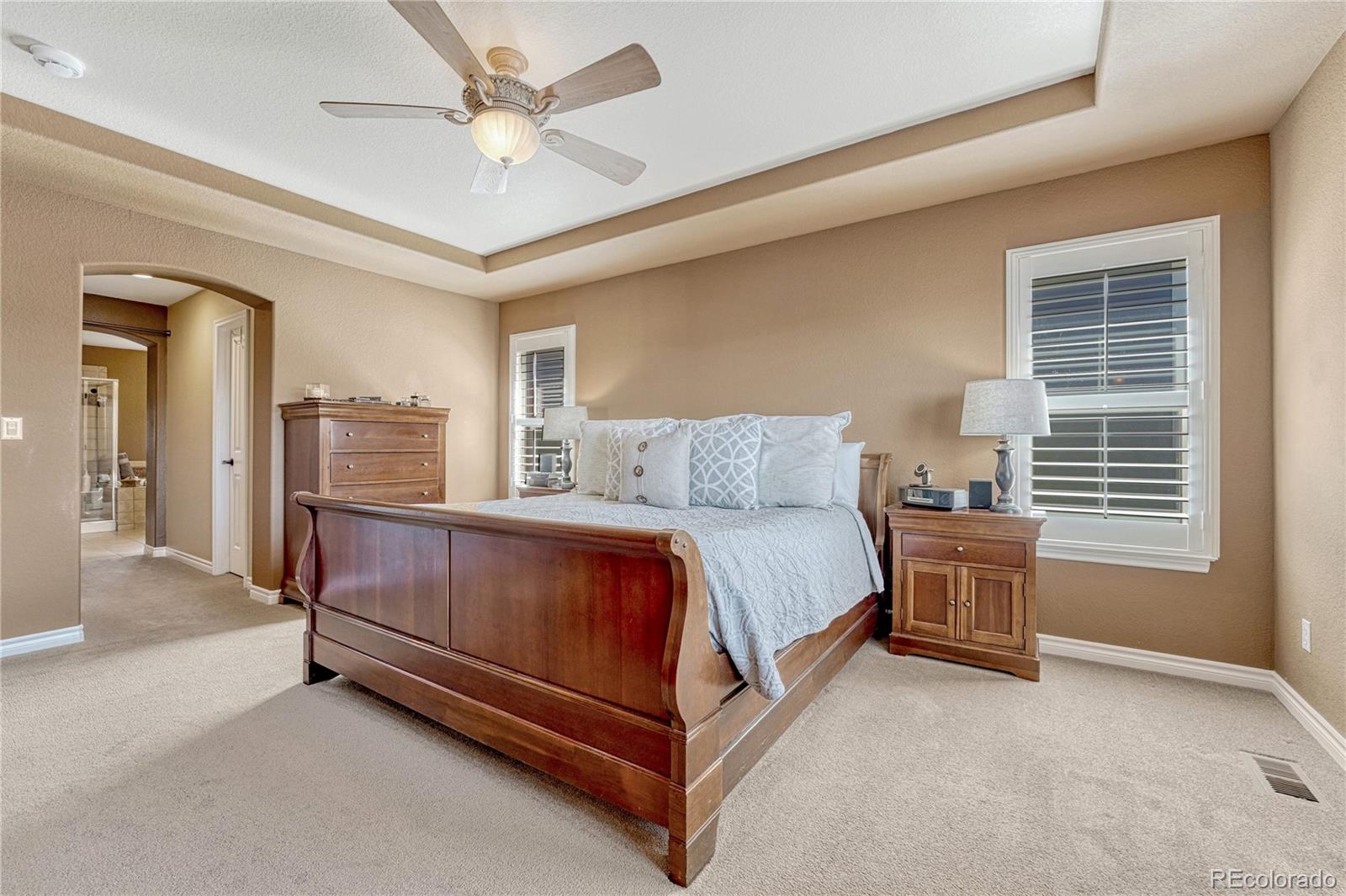 10761 Glengate Circle Highlands Ranch, CO 80130 - Photo 22 of 39 a bedroom with a bed and a chandelier