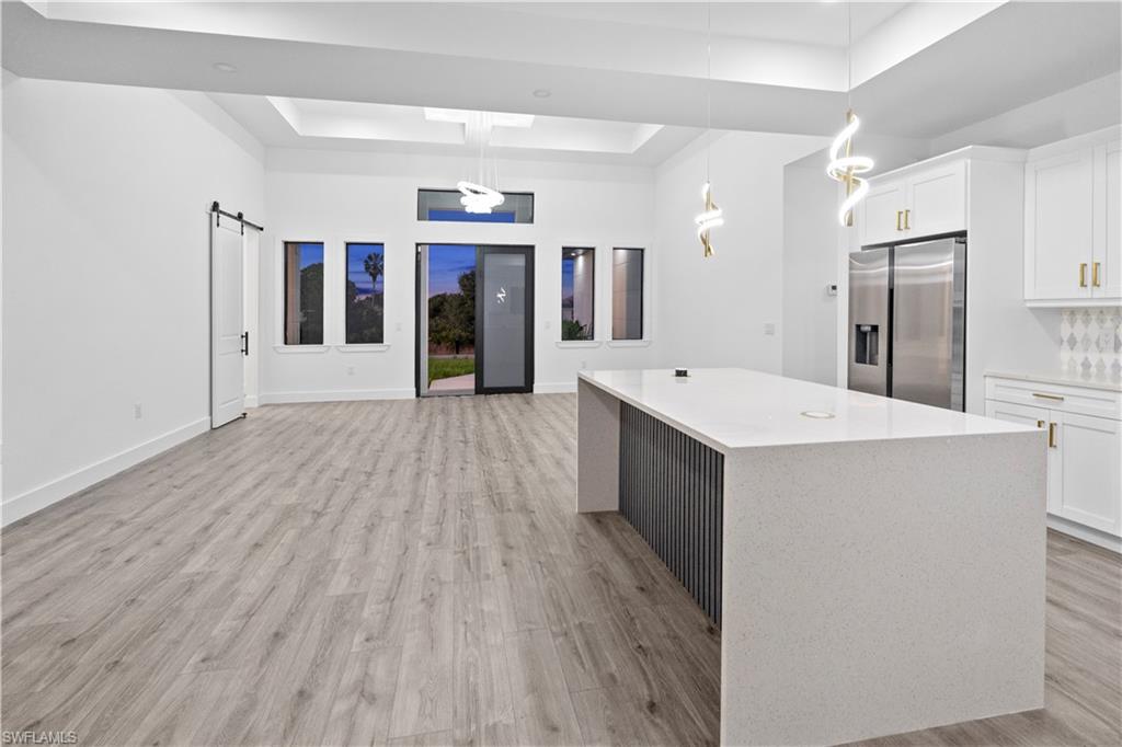 2714 24th Street West Lehigh Acres, FL 33971 - Photo 11 of 48 a large white kitchen with wooden floor
