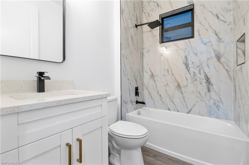 2714 24th Street West Lehigh Acres, FL 33971 - Photo 32 of 48 a bathroom with a sink a toilet and a bathtub