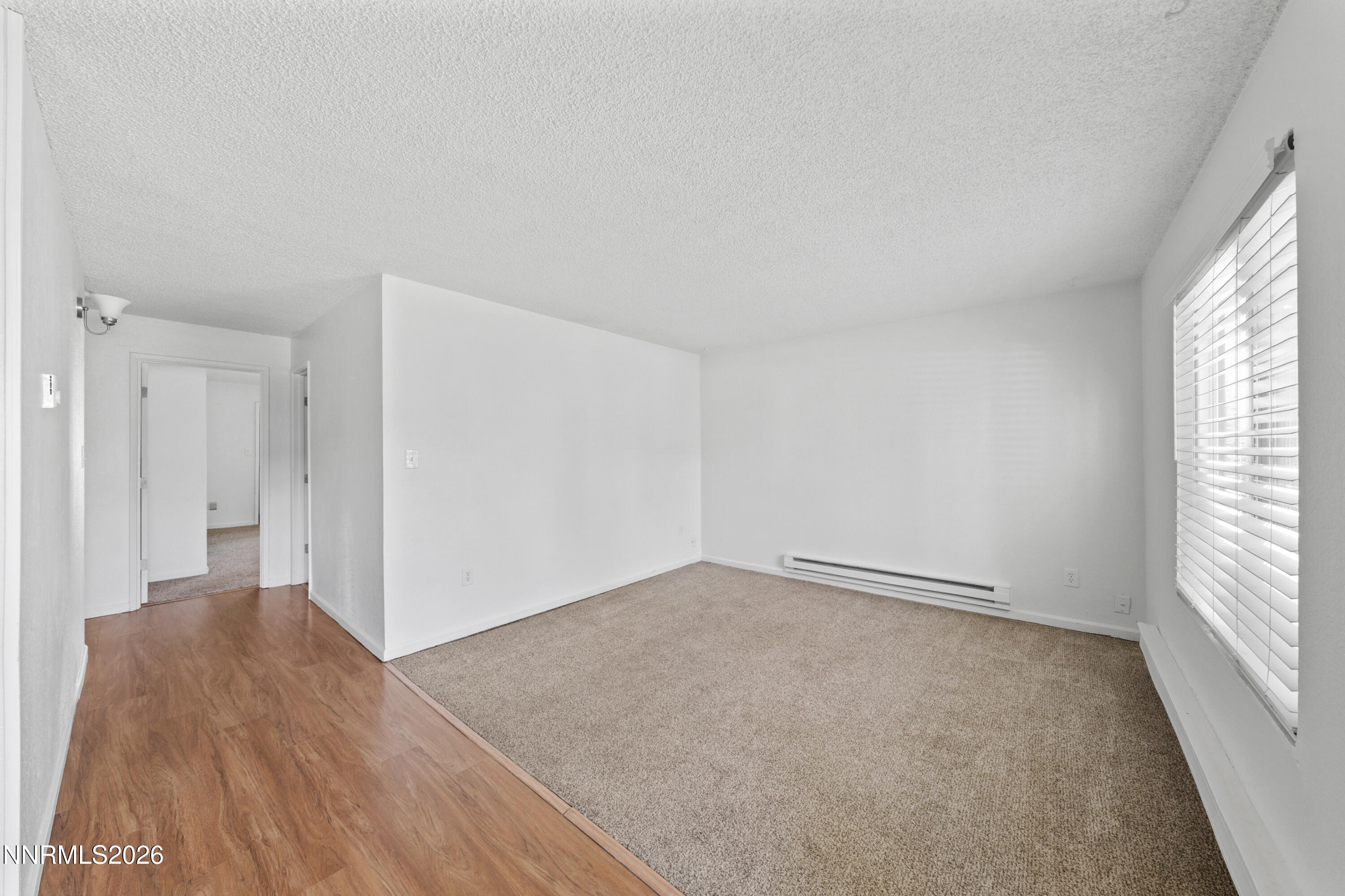 3942 Clear Acre Lane, Unit 241 Reno, NV 89512 - Photo 13 of 23 an empty room with wooden floor and windows