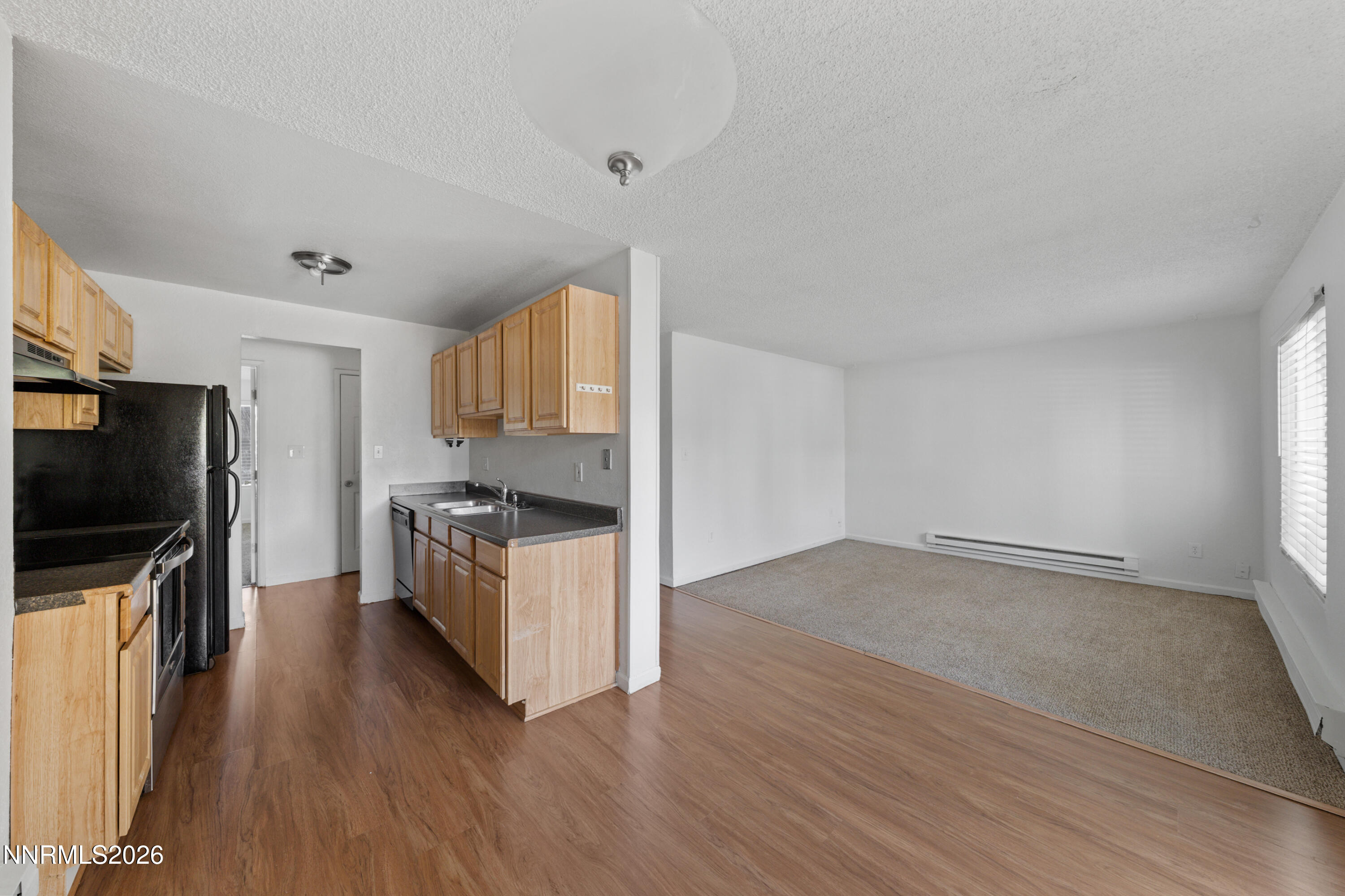 3942 Clear Acre Lane, Unit 241 Reno, NV 89512 - Photo 15 of 23 a kitchen with wooden floors and stainless steel appliances