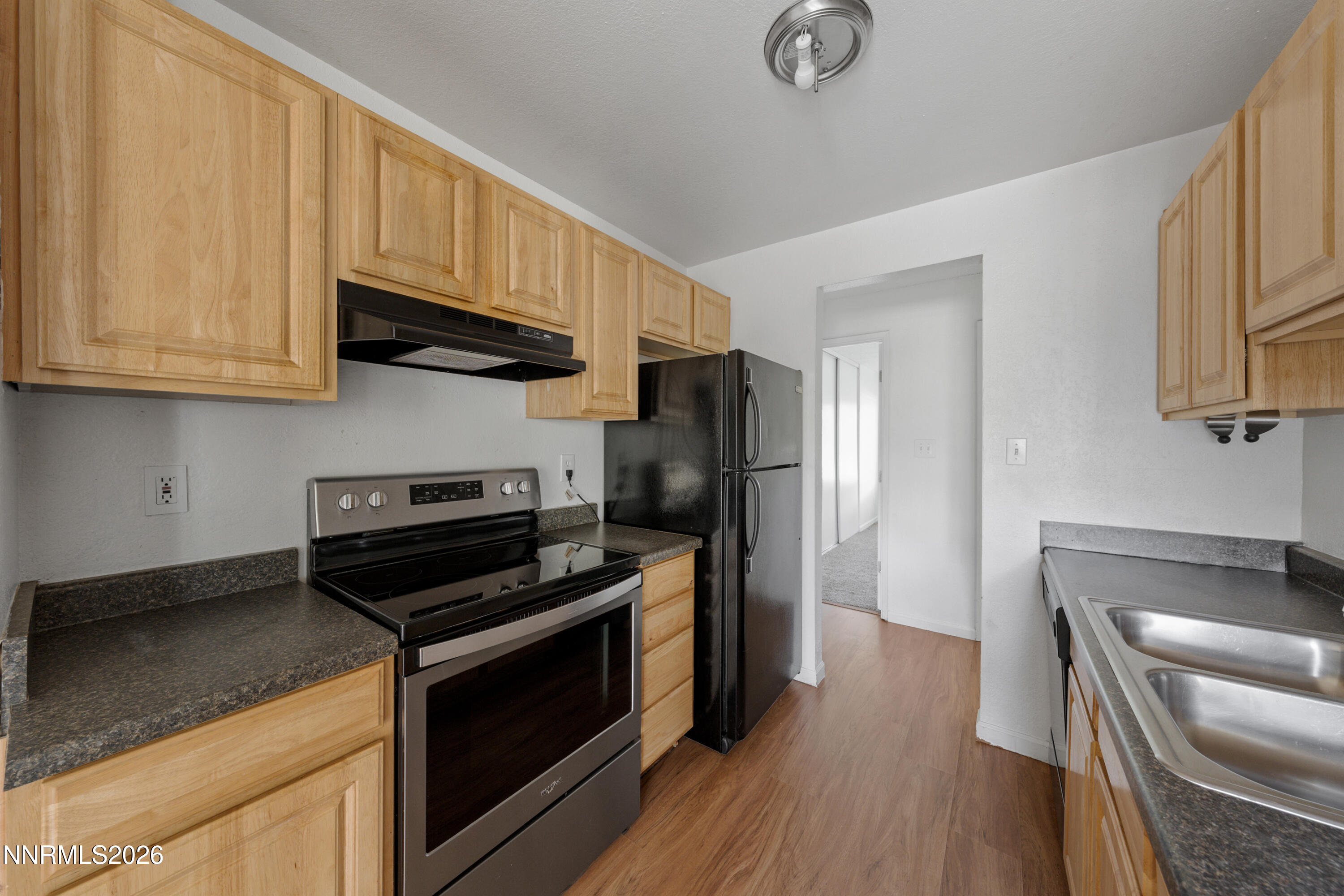 3942 Clear Acre Lane, Unit 241 Reno, NV 89512 - Photo 16 of 23 a kitchen with stainless steel appliances granite countertop a stove a refrigerator and a microwave