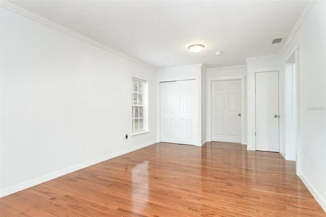 a view of an empty room with wooden floor