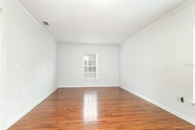 a view of a room with wooden floor and white walls