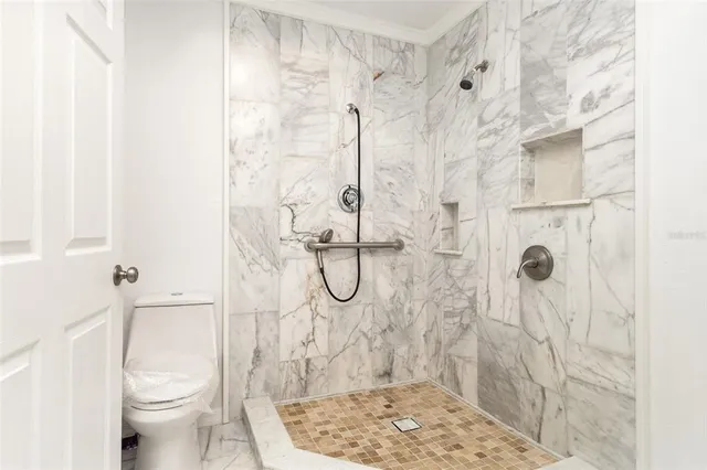 a bathroom with a granite countertop shower a toilet and sink