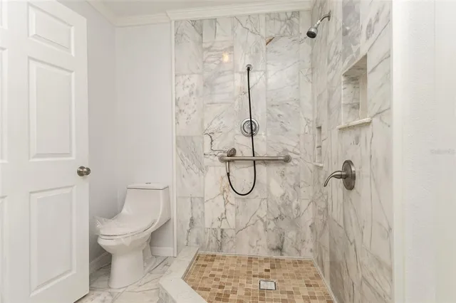 a bathroom with a granite countertop shower and a toilet