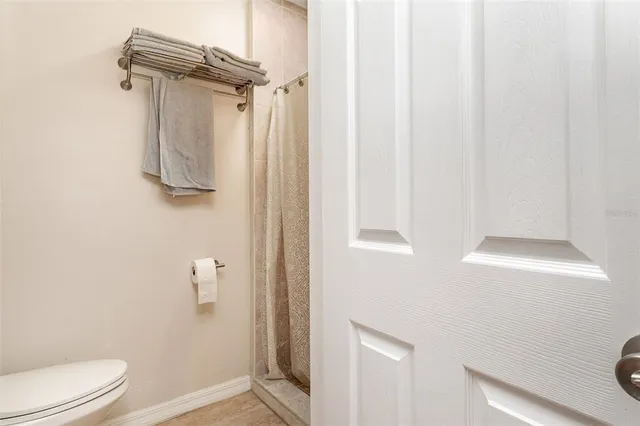 a bathroom with a shower a toilet and a window