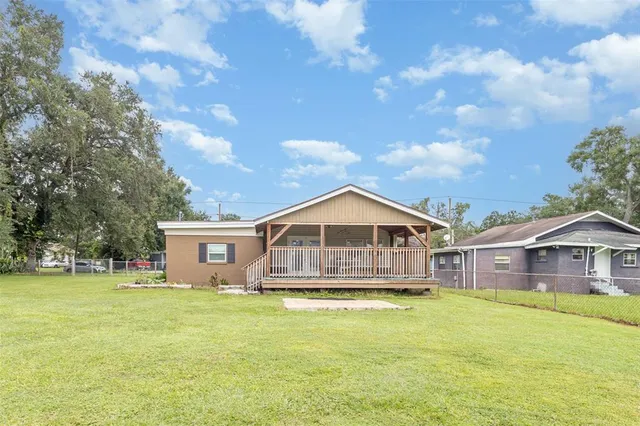a front view of a house with a garden and trees