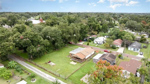 an aerial view of residential houses with outdoor space and trees