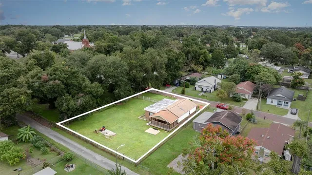 a front view of a house with a garden and trees