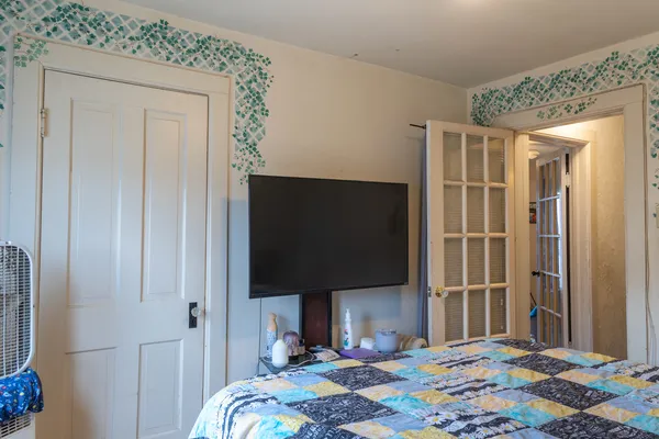 a bedroom with a bed and a flat screen tv