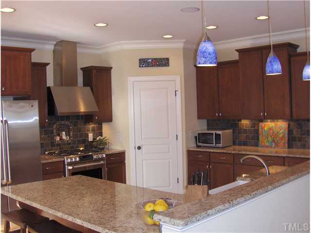 1716 Struble Circle Willow Spring, NC 27592 - Photo 9 of 25 a kitchen with stainless steel appliances granite countertop a sink a stove and a refrigerator