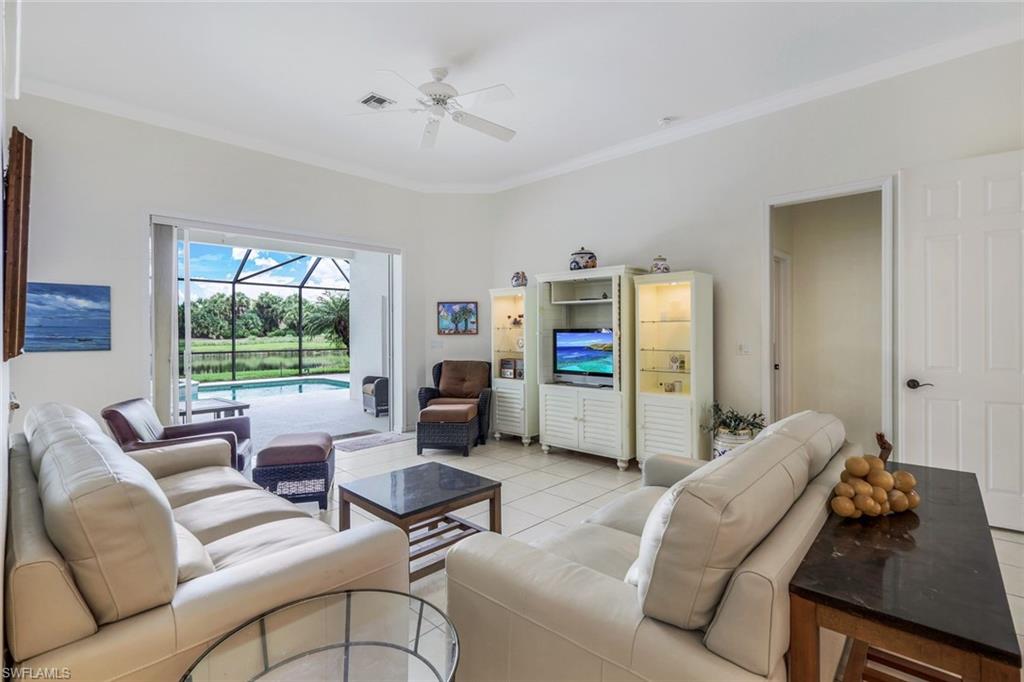 17983 Modena Road Miromar Lakes, FL 33913 - Photo 5 of 44 Tiled living room with ornamental molding and ceiling fan