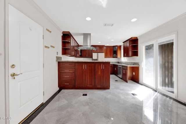 a kitchen with stainless steel appliances granite countertop a refrigerator and a stove top oven
