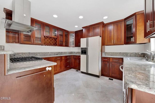 a kitchen with stainless steel appliances granite countertop a stove a refrigerator and a stove