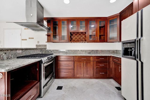 a kitchen with stainless steel appliances granite countertop a stove and a refrigerator