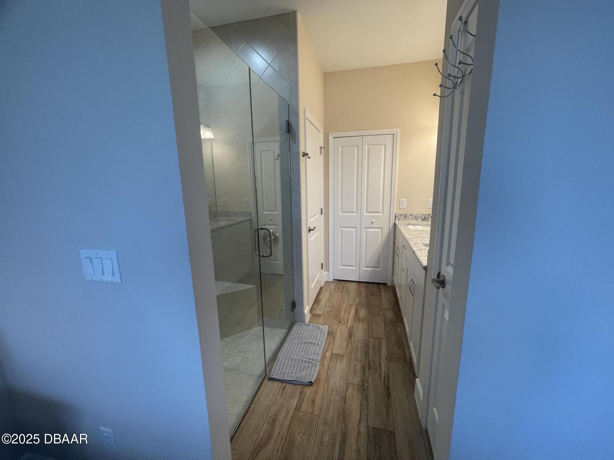 231 Ocean Hammock Loop Daytona Beach, FL 32124 - Photo 13 of 39 a view of a hallway with wooden floor and a bathroom