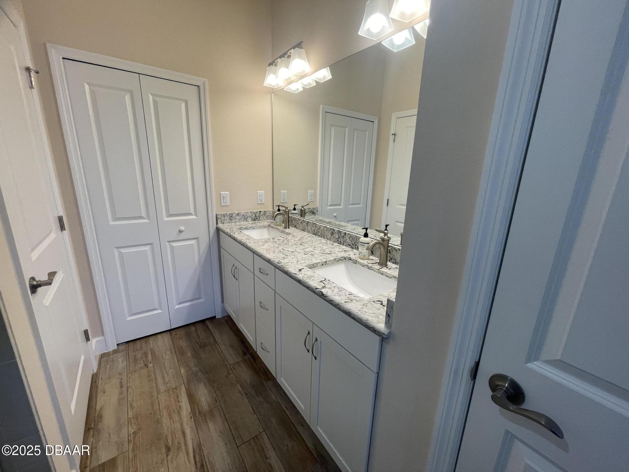 231 Ocean Hammock Loop Daytona Beach, FL 32124 - Photo 15 of 39 a bathroom with a granite countertop sink and a mirror