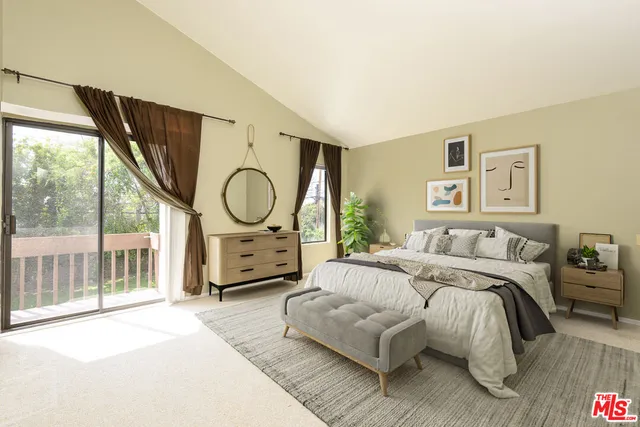 a spacious bedroom with a bed a large window with table and chair