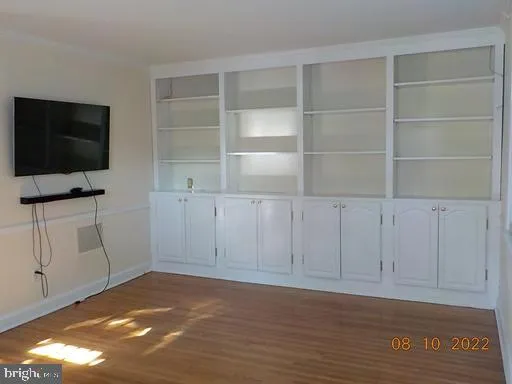 a view of an empty room with cabinet and a flat screen tv