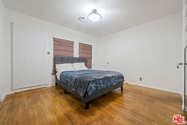 a bedroom with a bed and wooden floor