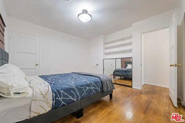 a bedroom with a bed and wooden floor