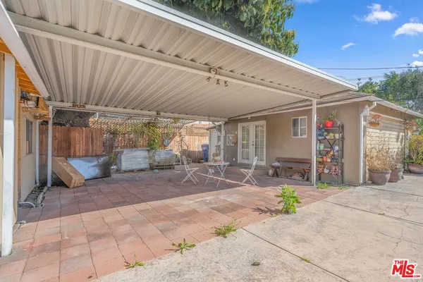 a view of a patio with table and chairs under an umbrella with a patio