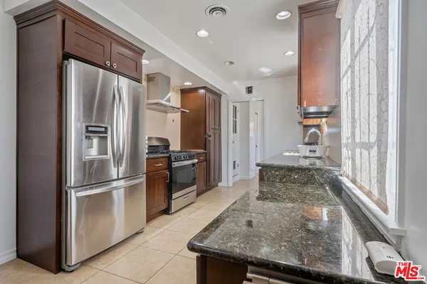 a kitchen with stainless steel appliances granite countertop a refrigerator and a sink