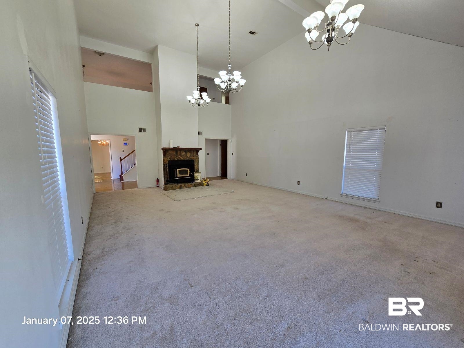 154 Byrd Road Monroeville, AL 36460 - Photo 8 of 26 Unfurnished living room featuring an inviting chandelier, light colored carpet, and high vaulted ceiling