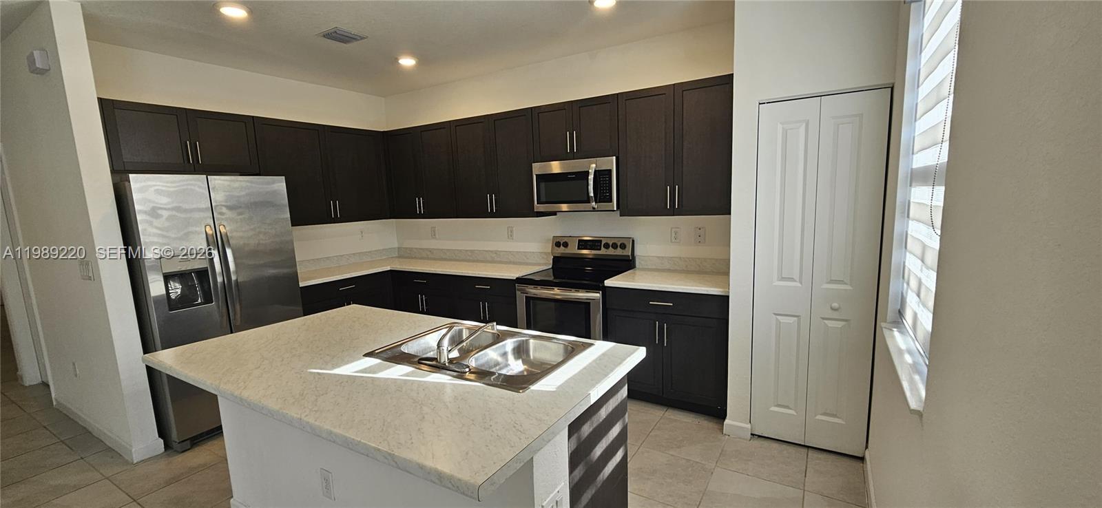 a kitchen with a refrigerator a stove a microwave and island